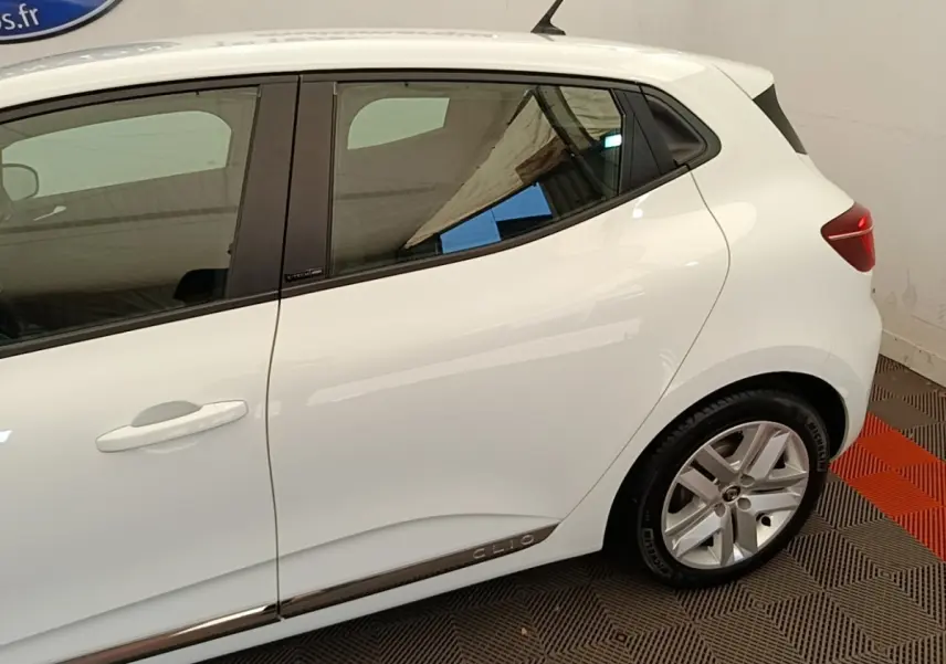 Vue latérale droite d'une Renault Clio blanche Business E-TECH 140 avec jantes alliage et logo Clio sur la bas de porte.