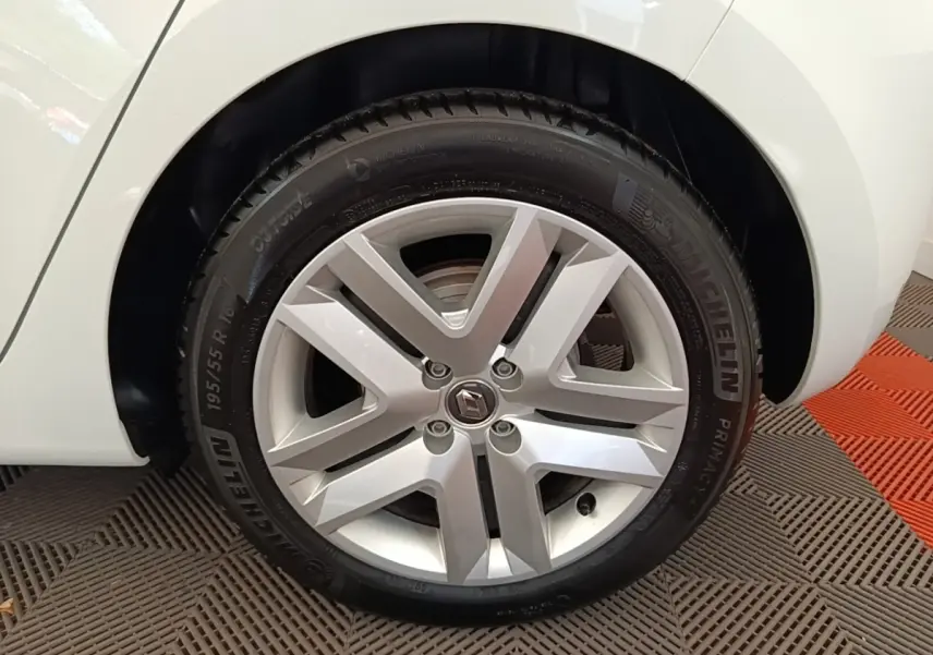 Gros plan sur la roue avant droite blanche d'une Renault Clio Business E-TECH 140 avec jante alliage et pneu Michelin.