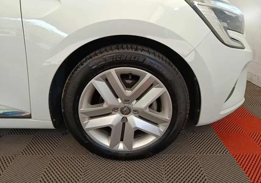 Gros plan sur la roue avant droite et partie du pare-chocs avant d'une Renault Clio Business E-TECH blanche.