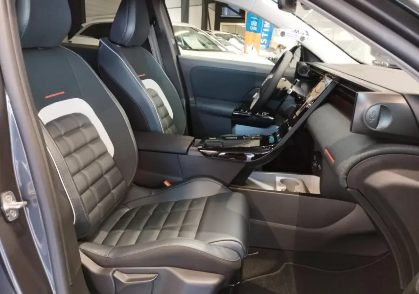 Vue intérieure côté conducteur du Citroën C5 Aircross gris platine, sièges cuir et tissu bleu avec console centrale noire brillante.