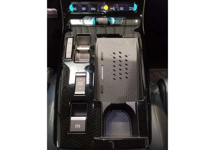 Vue rapprochée de la console centrale noire brillante du Citroën C5 Aircross 2026 avec commandes et recharge sans fil.
