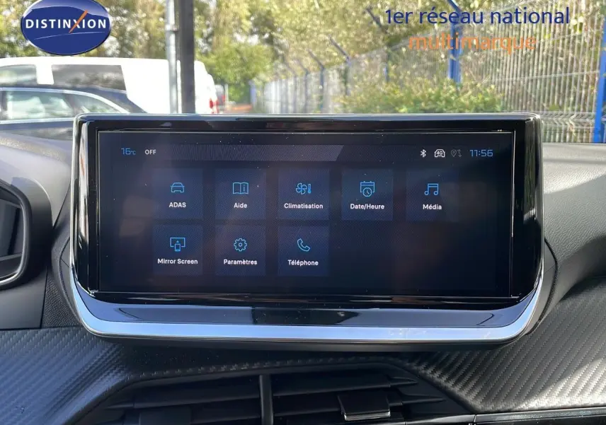 Écran tactile central du tableau de bord du Peugeot 2008 gris Artense, affichant les menus d'aide et climatisation.