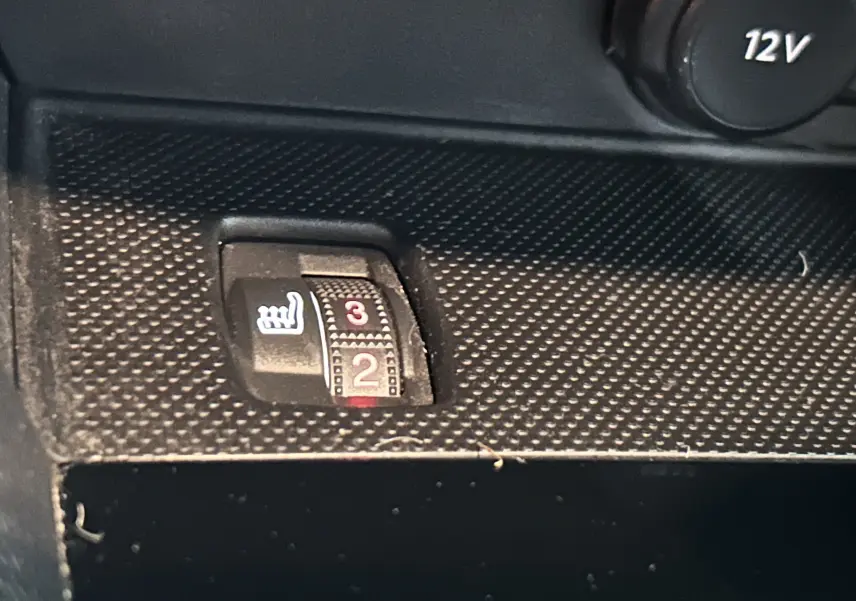 Gros plan sur le bouton de réglage de la chauffe siège en position 2, intérieur noir texturé de la Peugeot 308 gris 2021.