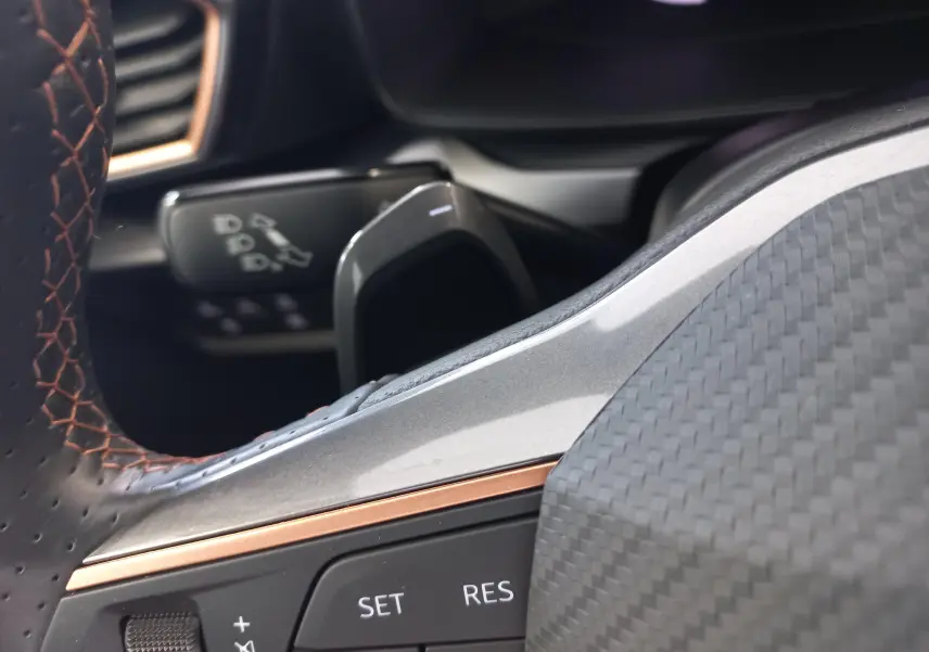 Gros plan sur le volant avec surpiqûres cuivre et commandes intégrées du CUPRA Leon Phase 2 2025.