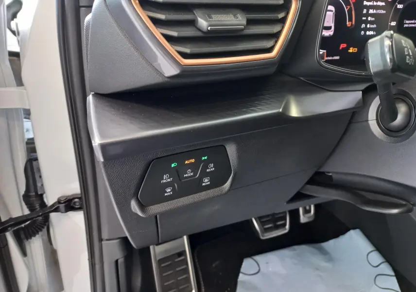 Détail intérieur côté gauche du tableau de bord de la CUPRA Leon blanc Nevada avec commandes d’éclairage et ventilation.