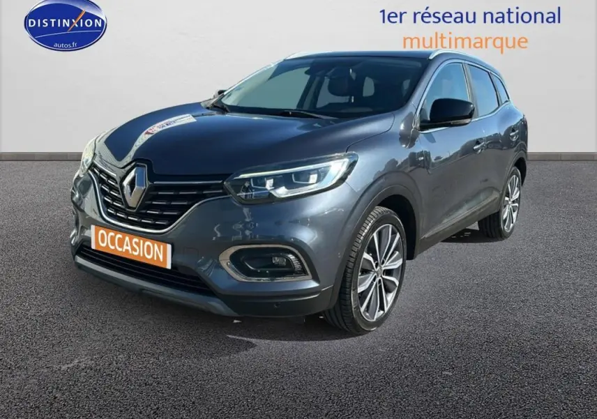 Renault Kadjar gris foncé vu en 3/4 avant droit, avec jantes alliage 19 pouces et feux allumés.