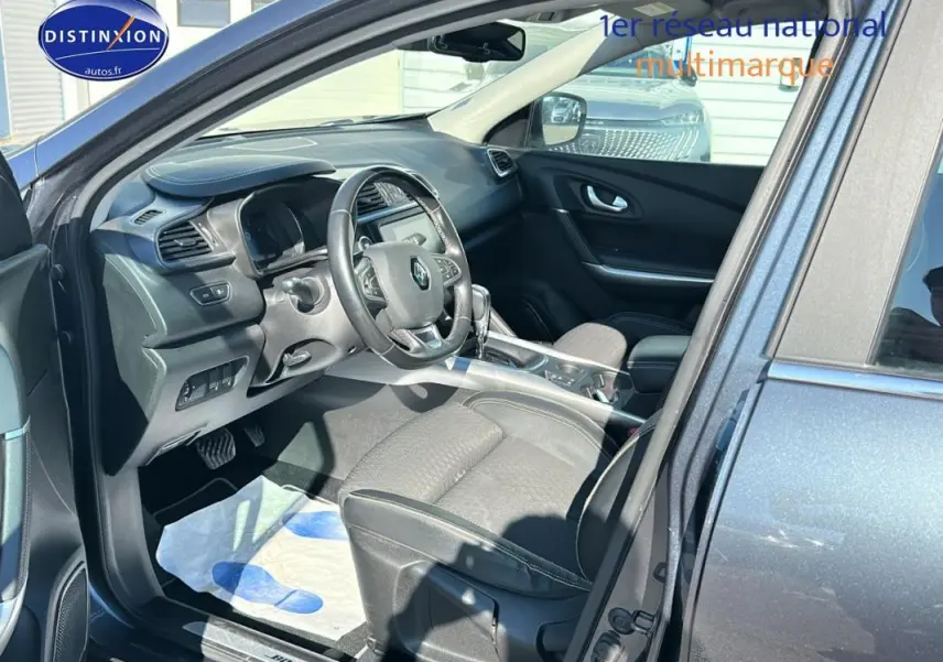 Intérieur du Renault Kadjar gris foncé vu côté conducteur, volant cuir et écran tactile au tableau de bord.