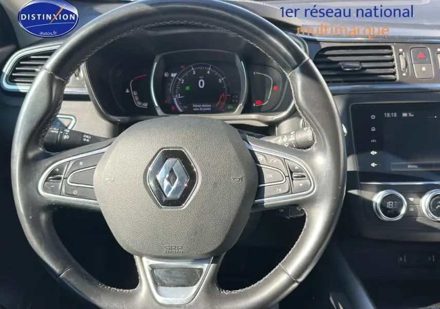 Vue rapprochée du volant cuir et du tableau de bord du Renault Kadjar gris foncé avec écran tactile et commandes au volant.