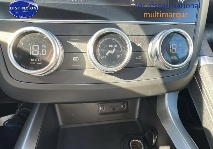 Gros plan sur la commande de climatisation automatique du Renault Kadjar gris foncé, avec réglage à 18°C.