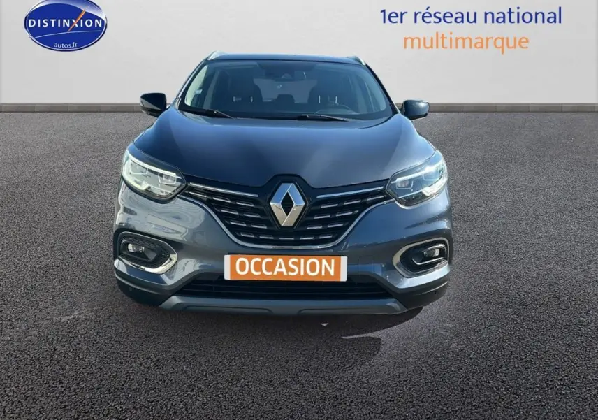 Vue frontale d'un Renault Kadjar gris foncé avec calandre noire et feux LED allumés sur fond neutre.