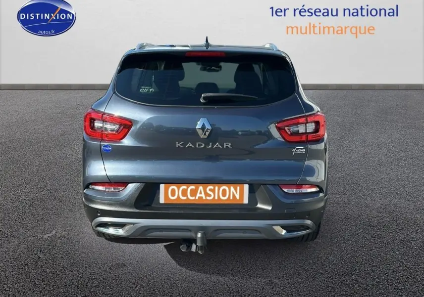Vue arrière d'un Renault Kadjar gris foncé avec barres de toit et attelage visible sur un parking.