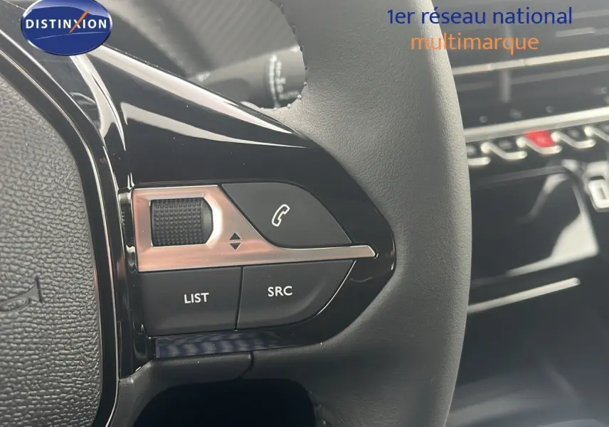 Gros plan sur les commandes gauche du volant noir du Peugeot 2008 blanc Okenite Metal, avec boutons de téléphone et liste.