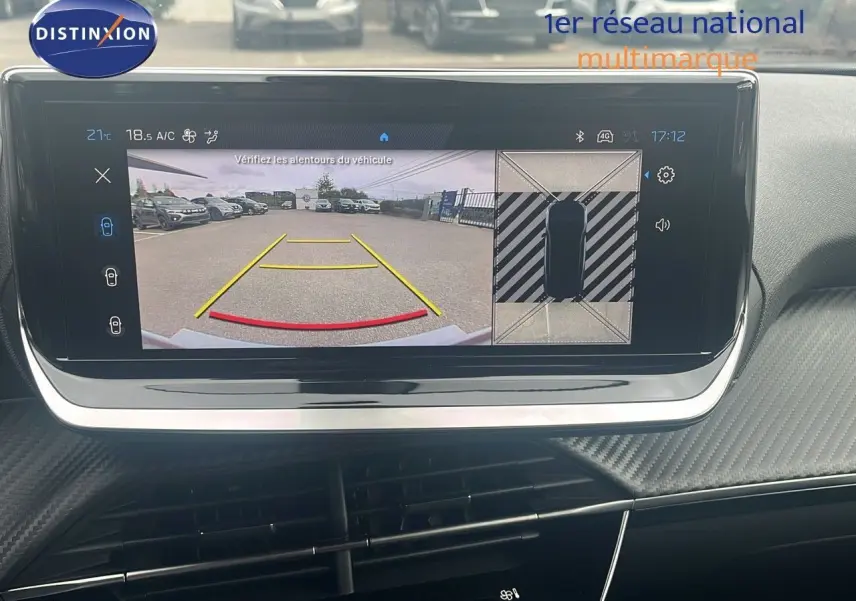 Écran intérieur affichant la caméra de recul et vue 360° d'une Peugeot 2008 blanche, tableau de bord moderne.