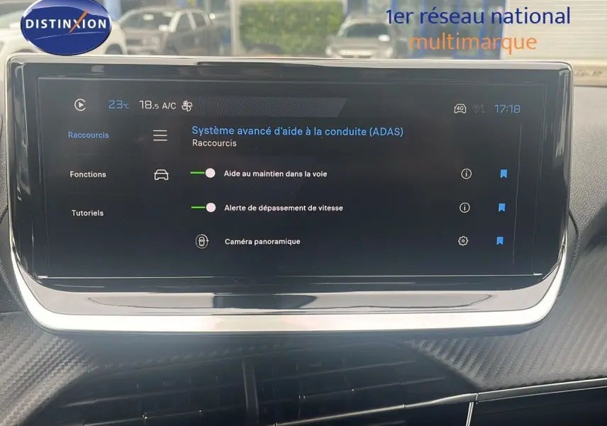 Écran tactile central du Peugeot 2008 blanc, affichant les aides à la conduite et la caméra panoramique.