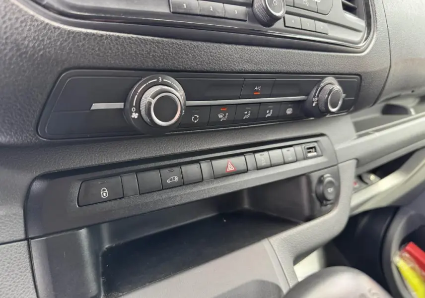 Détail de la console centrale noire du Peugeot Expert Fourgon 2018, montrant les commandes de climatisation et les boutons de fonction.