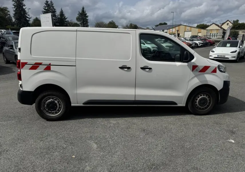 Peugeot Expert Fourgon blanc vue de profil côté gauche avec bandes rouges réfléchissantes sur ailes avant et arrière.