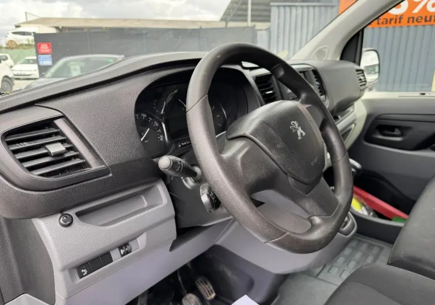 Vue intérieure côté conducteur du Peugeot Expert Fourgon 2018, volant noir et tableau de bord gris foncé.