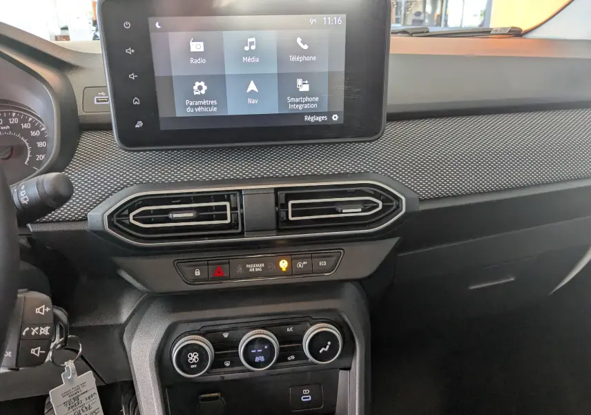 Vue intérieure du tableau de bord du Dacia Jogger 2025, avec écran tactile central et commandes de climatisation.