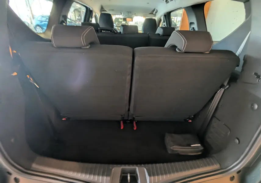 Vue arrière du coffre du Dacia Jogger 2025, sièges arrière noirs relevés, intérieur spacieux sans chargement visible.