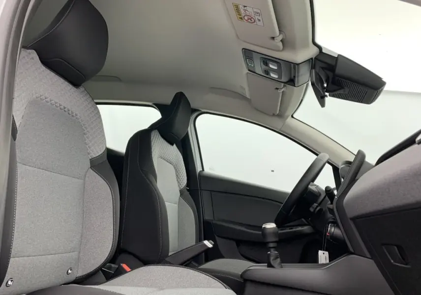 Intérieur avant droit de la Renault Clio V TCE 90 GSR2 Evolution avec sellerie textile gris à motif 3D et volant textile enduit grainé.