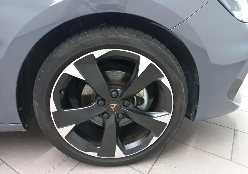 Gros plan sur la roue avant droite d'une CUPRA Leon gris Graphene avec jante noire et argentée au design distinctif.