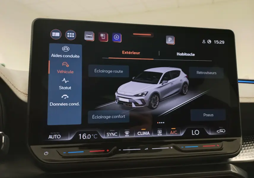 Écran tactile intérieur montrant une vue 3/4 avant d'une CUPRA Leon blanche Nevada sur l'interface du véhicule.