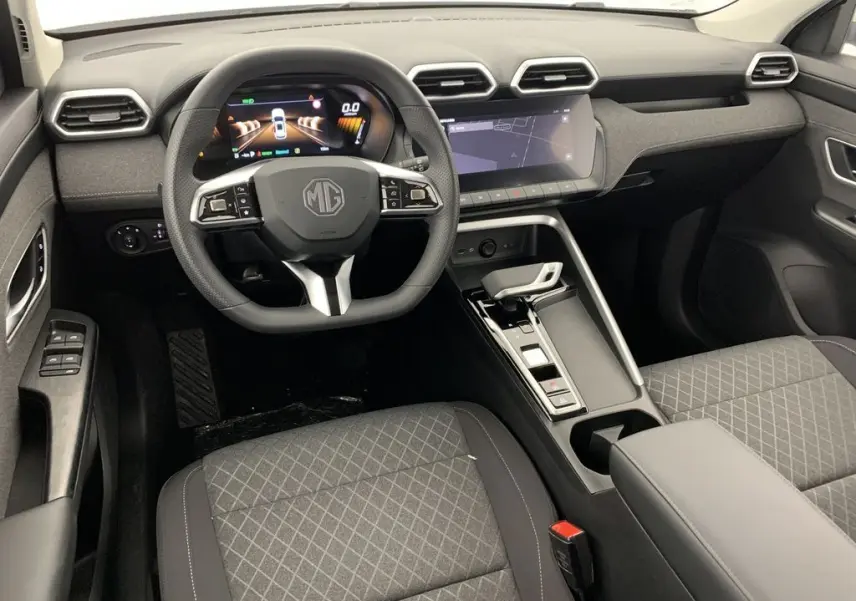 Vue intérieure du poste de conduite du MG ZS 1.5L Hybrid+ 2026, tableau de bord noir avec écran digital et volant multifonction.
