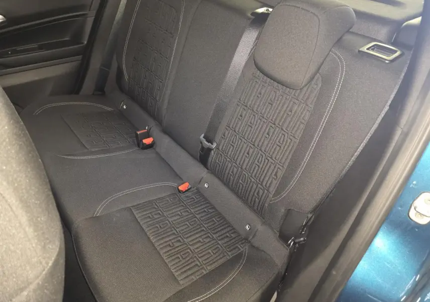 Vue intérieure côté droit sur la banquette arrière noire avec motifs FIAT, porte bleue métallisée ouverte visible.
