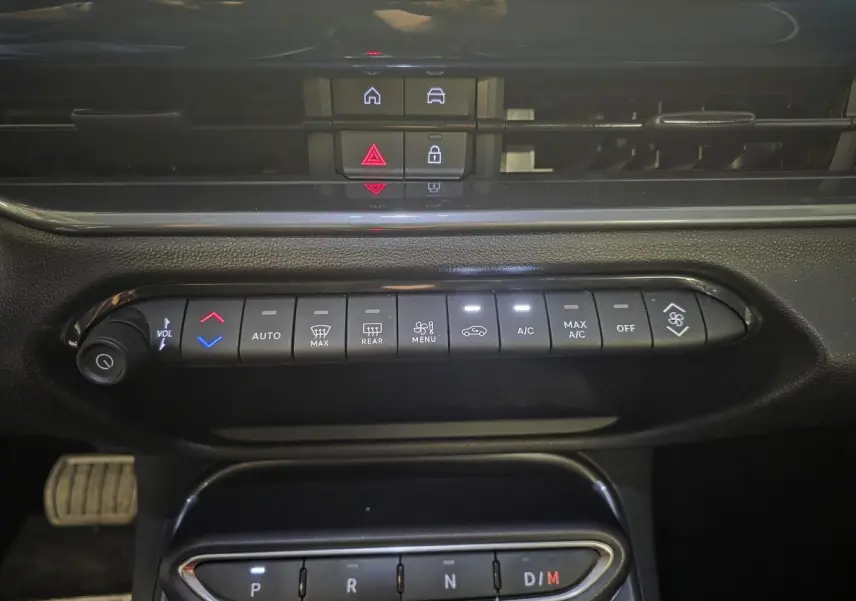 Vue rapprochée du tableau de bord de la Fiat 600 Hybrid 2025, montrant les commandes climatisation et boîte automatique.