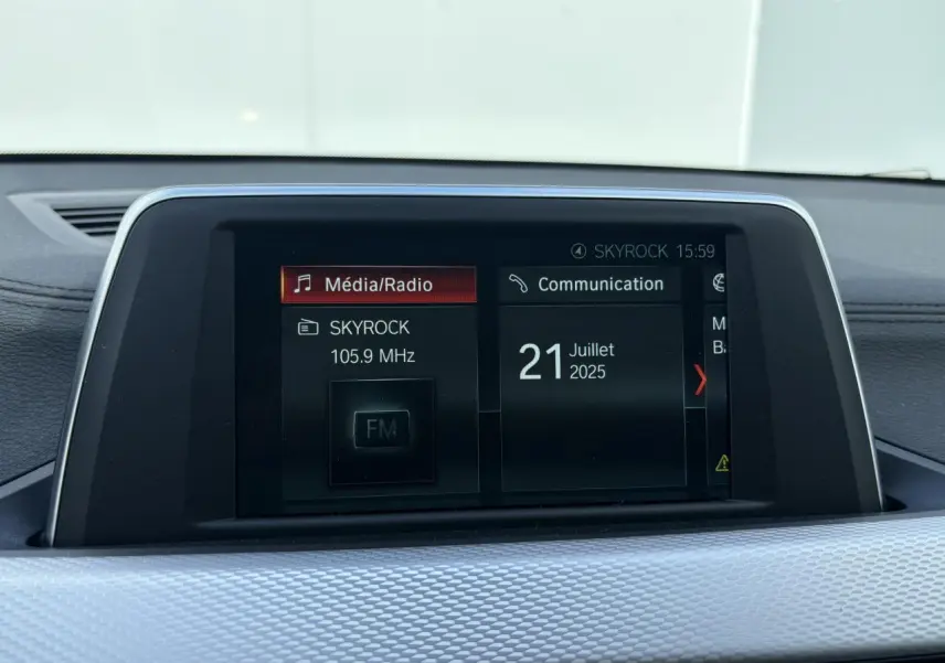 Écran multimédia central du BMW X2 blanc alpin, affichant la radio Skyrock et la date du 21 juillet 2025.