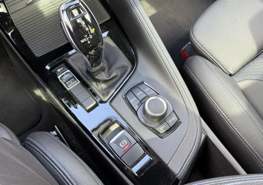 Console centrale en cuir noir avec levier de vitesses automatique et commandes multimédia du BMW X2 blanc Alpin 2021.