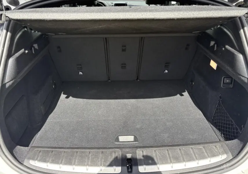 Coffre ouvert d'un BMW X2 blanc alpin (F39) montrant un espace de chargement propre et bien agencé.