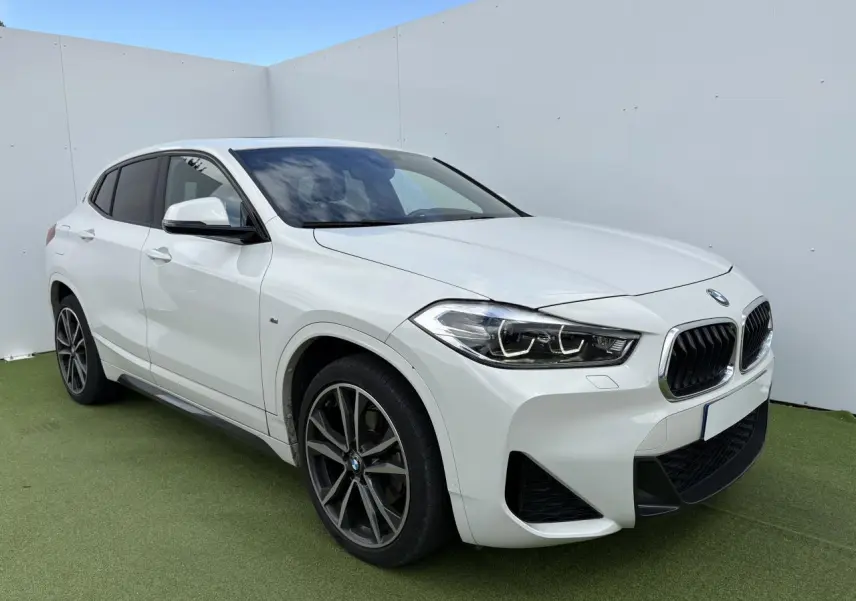 BMW X2 blanc alpin en 3/4 avant droit avec jantes M 19 pouces et toit ouvrant panoramique visible