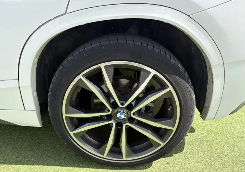 Gros plan sur la roue arrière droite d'une BMW X2 blanche avec jante alliage 19 pouces style 715 M.