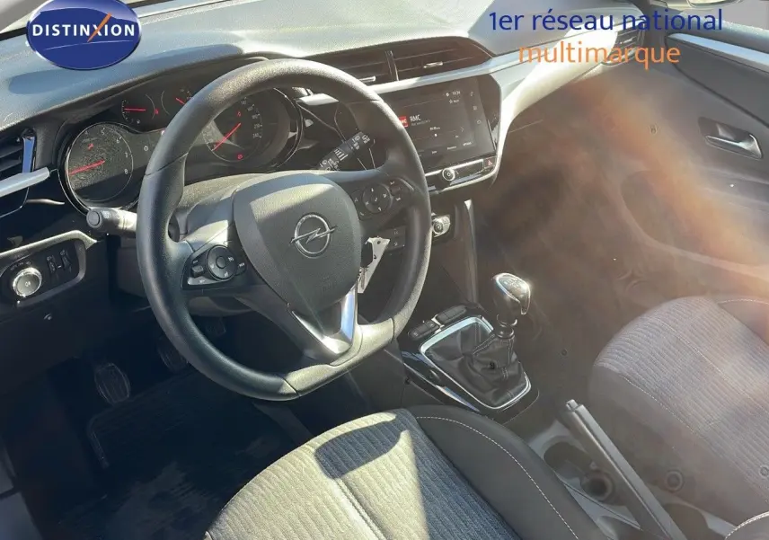 Vue intérieure de l’Opel Corsa 1.5D 102CH Edition 2022 montrant le volant, la boîte manuelle et les sièges tissu gris.