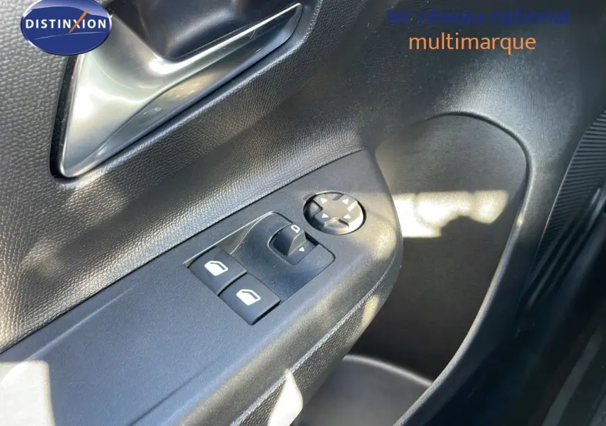 Gros plan sur la commande des vitres électriques côté conducteur de l'Opel Corsa blanc glacier 2022.