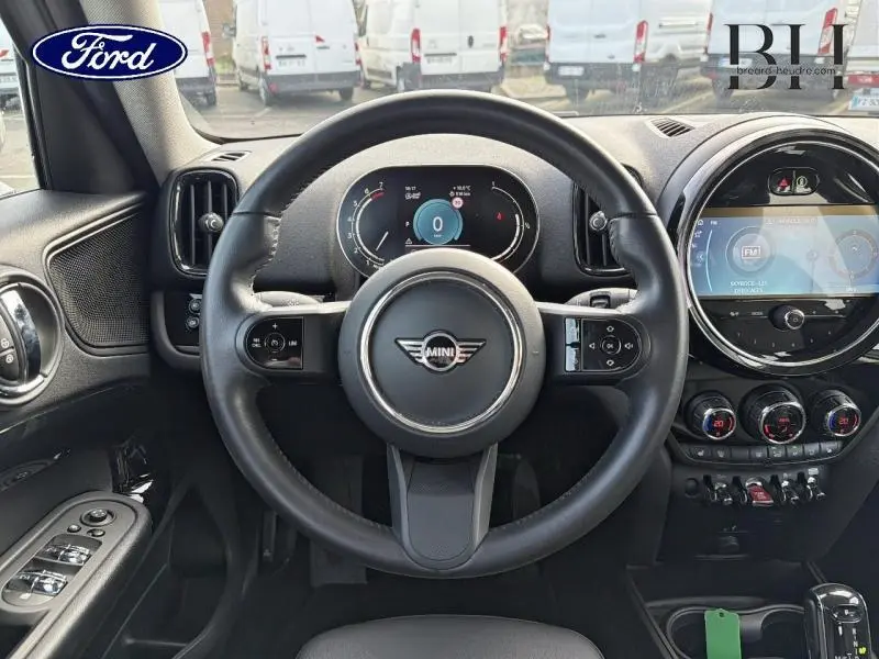 Vue intérieure centrée sur le volant cuir noir multifonction d'une MINI Countryman Melting Silver III avec tableau de bord numérique.