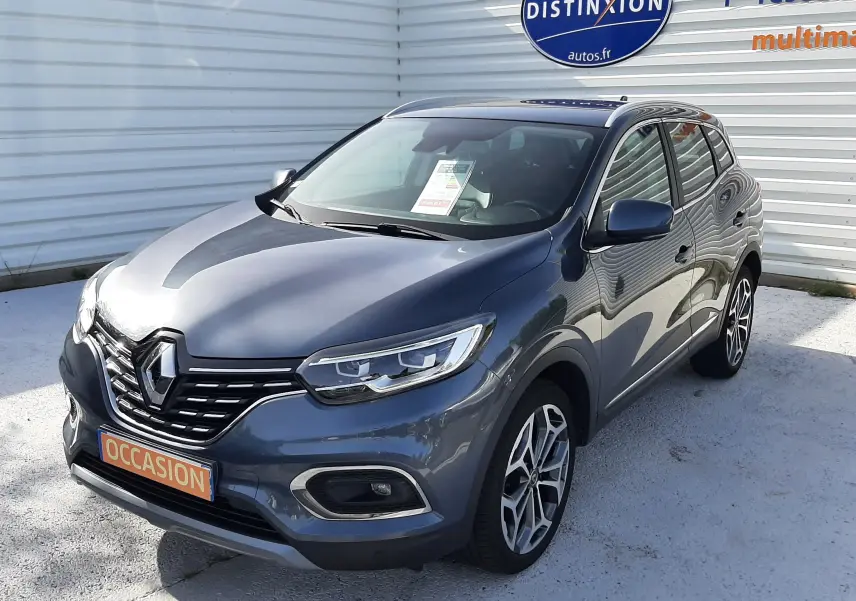 Renault Kadjar gris titanium en 3/4 avant droit, SUV compact avec jantes alliage et calandre noire distinctive.