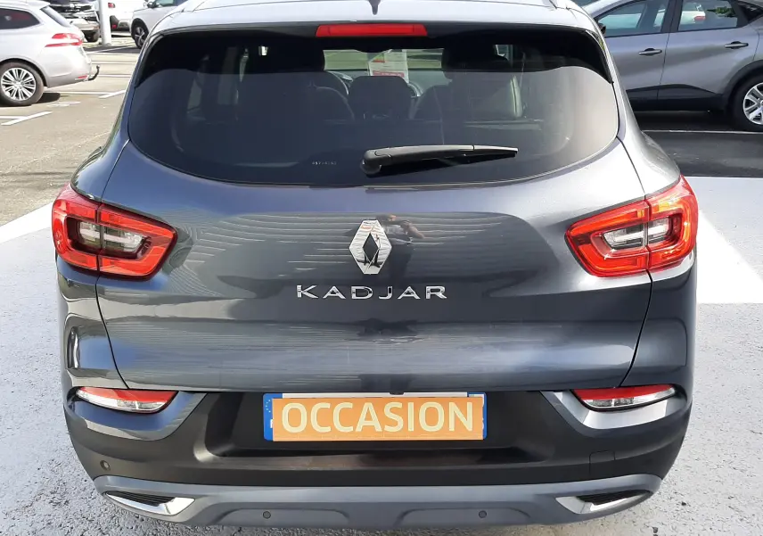 Vue arrière d'un Renault Kadjar gris titanium 2021 avec feux LED et plaque "OCCASION" visible sur un parking extérieur.