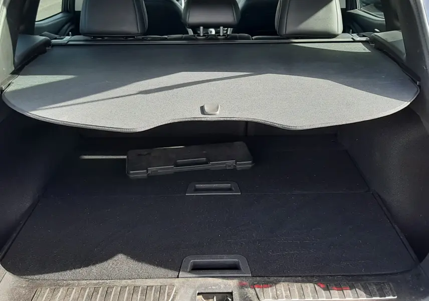 Coffre ouvert du Renault Kadjar gris titanium, vue arrière montrant la plage arrière et l’espace de chargement vide.