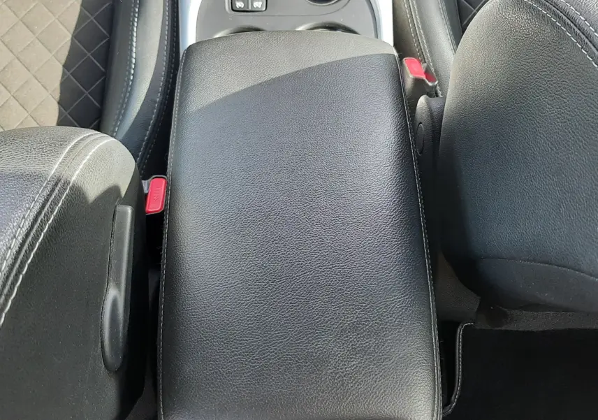 Vue plongeante sur l'accoudoir central en cuir noir et la console centrale du Renault Kadjar 1.5 Blue dCi 115ch Intens 2021.