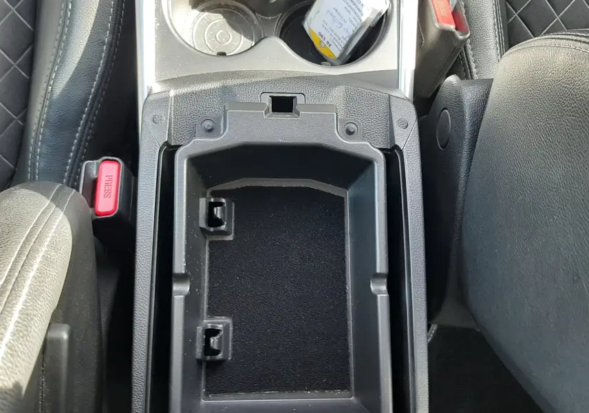 Vue rapprochée de la console centrale noire du Renault Kadjar 2021, avec porte-gobelets et accoudoir ouvert.