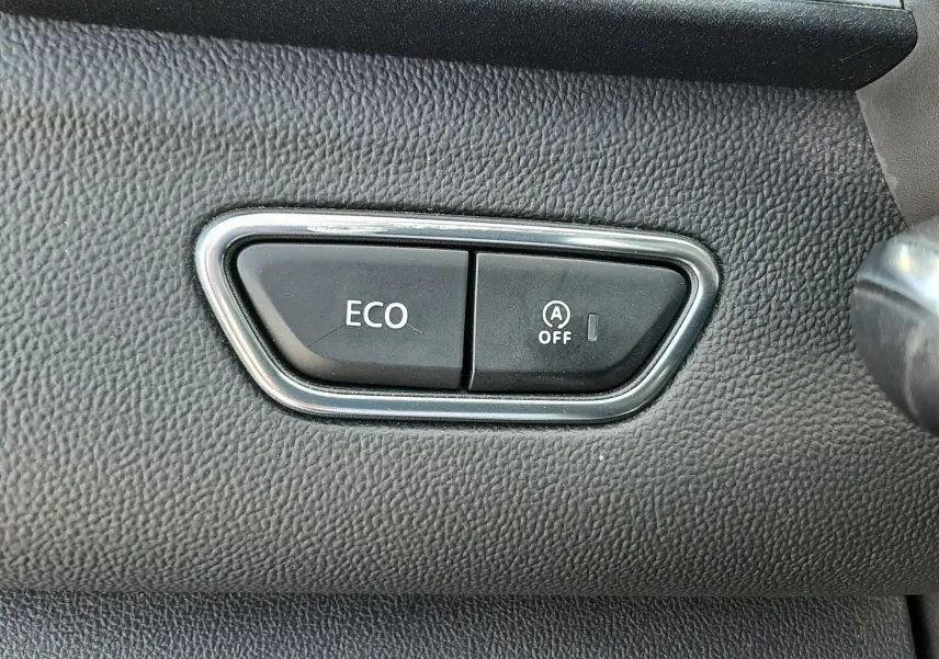 Gros plan sur les boutons ECO et désactivation du start-stop sur le tableau de bord noir du Renault Kadjar 2021.
