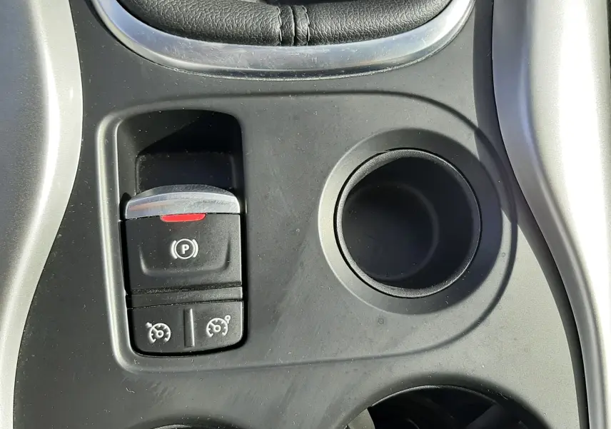 Gros plan sur la console centrale noire du Renault Kadjar 2021, avec frein à main électrique et porte-gobelets.
