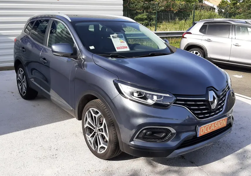 Renault Kadjar gris titanium en 3/4 avant droit, SUV compact avec jantes alliage et calandre noire brillante.