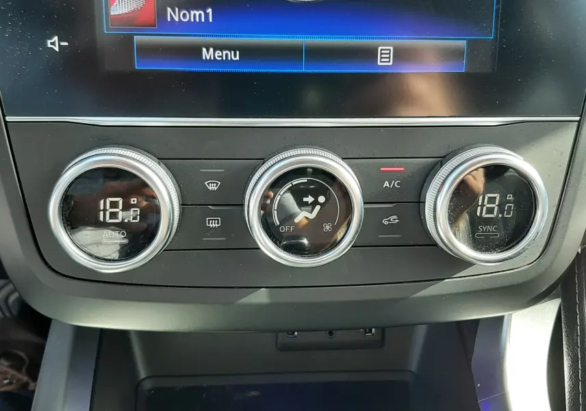 Gros plan sur la console centrale du Renault Kadjar 2021, montrant les commandes de climatisation digitales à 18°C.