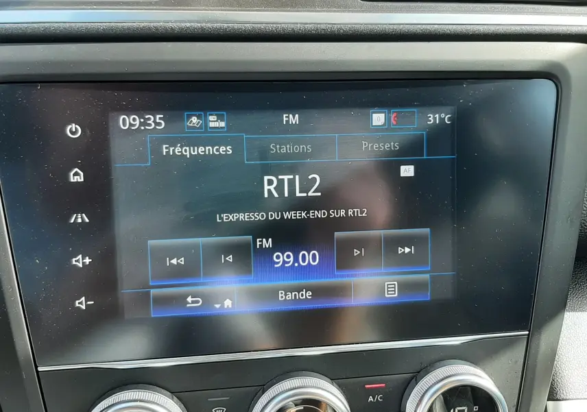 Vue rapprochée de l’écran multimédia et des commandes de climatisation du Renault Kadjar gris titanium, intérieur noir.