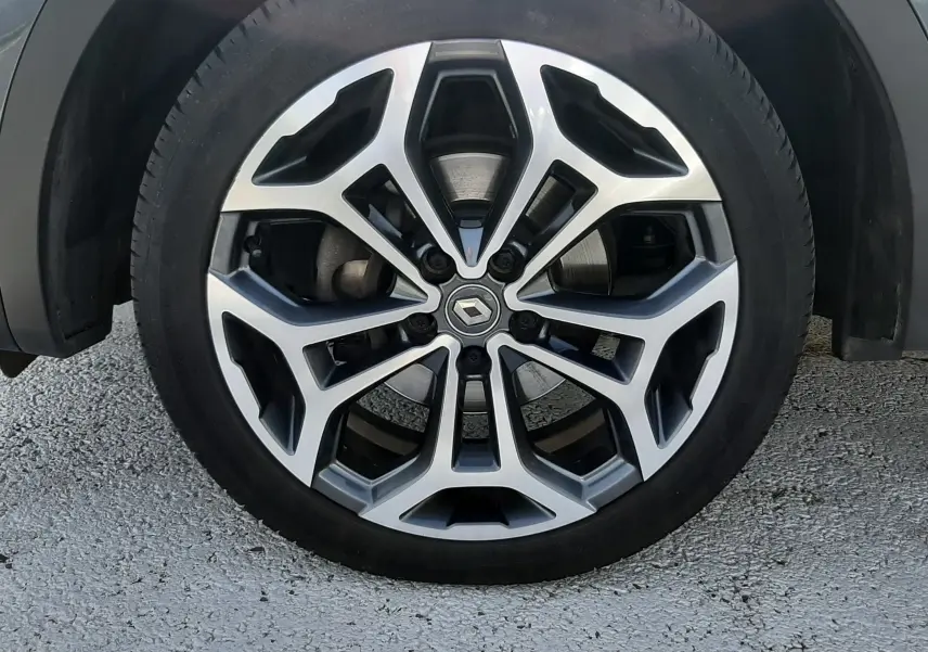 Gros plan sur la jante alliage bi-ton avec logo Renault, sur roue avant droite du Kadjar gris titanium.