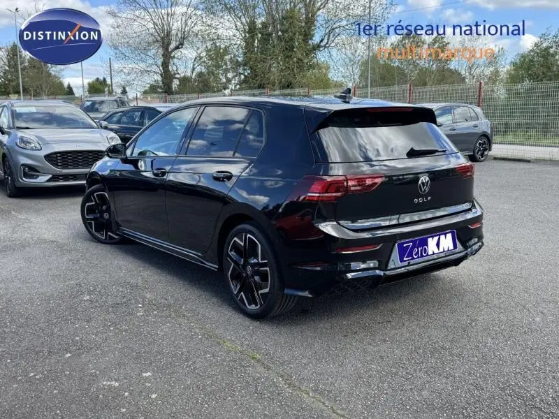 Vue 3/4 arrière droite d'une Volkswagen Golf noire métallisée avec jantes alu et vitres surteintées stationnée en extérieur.
