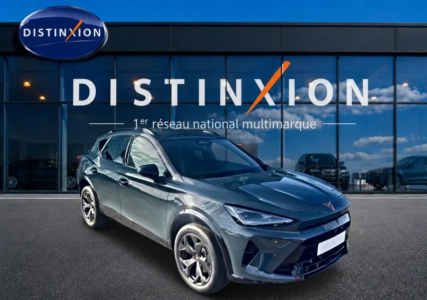 Vue 3/4 avant d'un CUPRA Formentor 1.5 etsi hybrid bleu fjord avec jantes 18 pouces devant un showroom Distinxion.